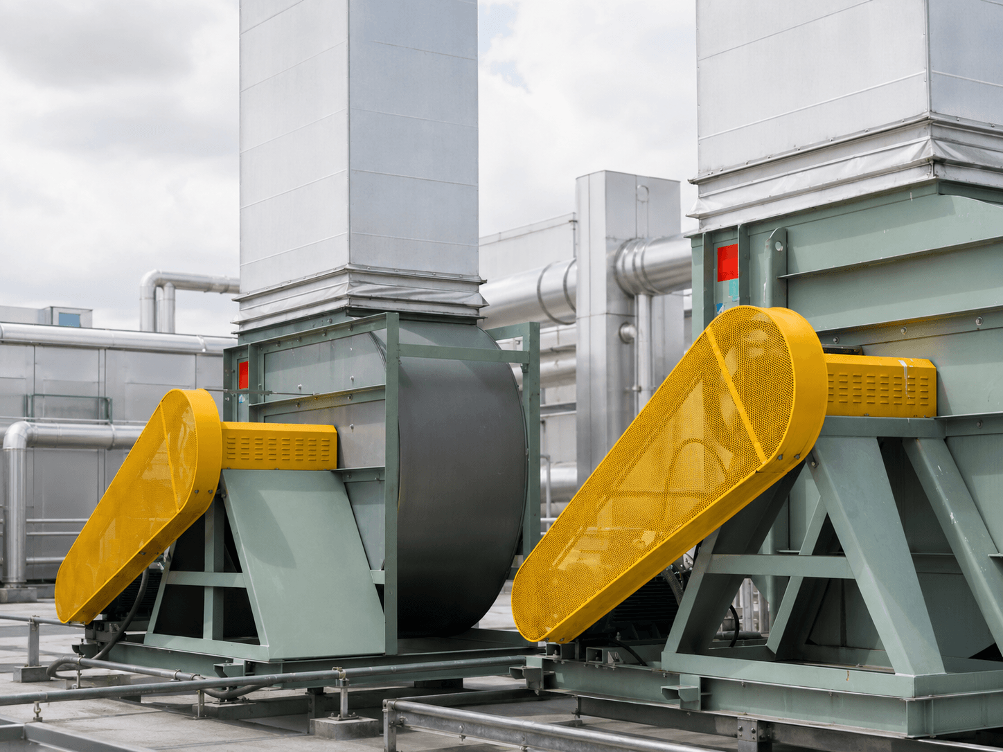 Yellow industrial machine guard over rooftop ventilation equipment